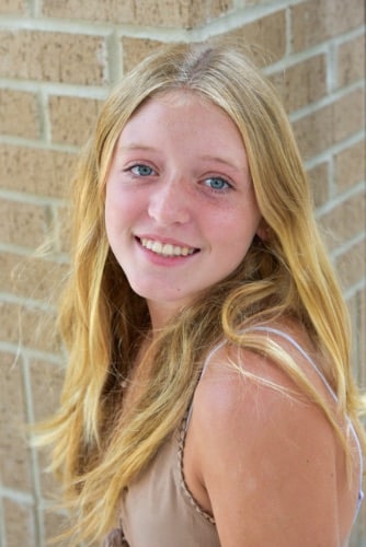 Maddux orthodontics patient young blonde girl smiling after treatment