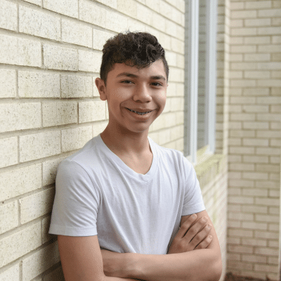 Teenage boy patient smiling and posing for a photo, representing best treatment for gaps between teeth