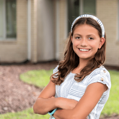 Teenage female patient, smiling and posing outdoors, representing public speaking with braces